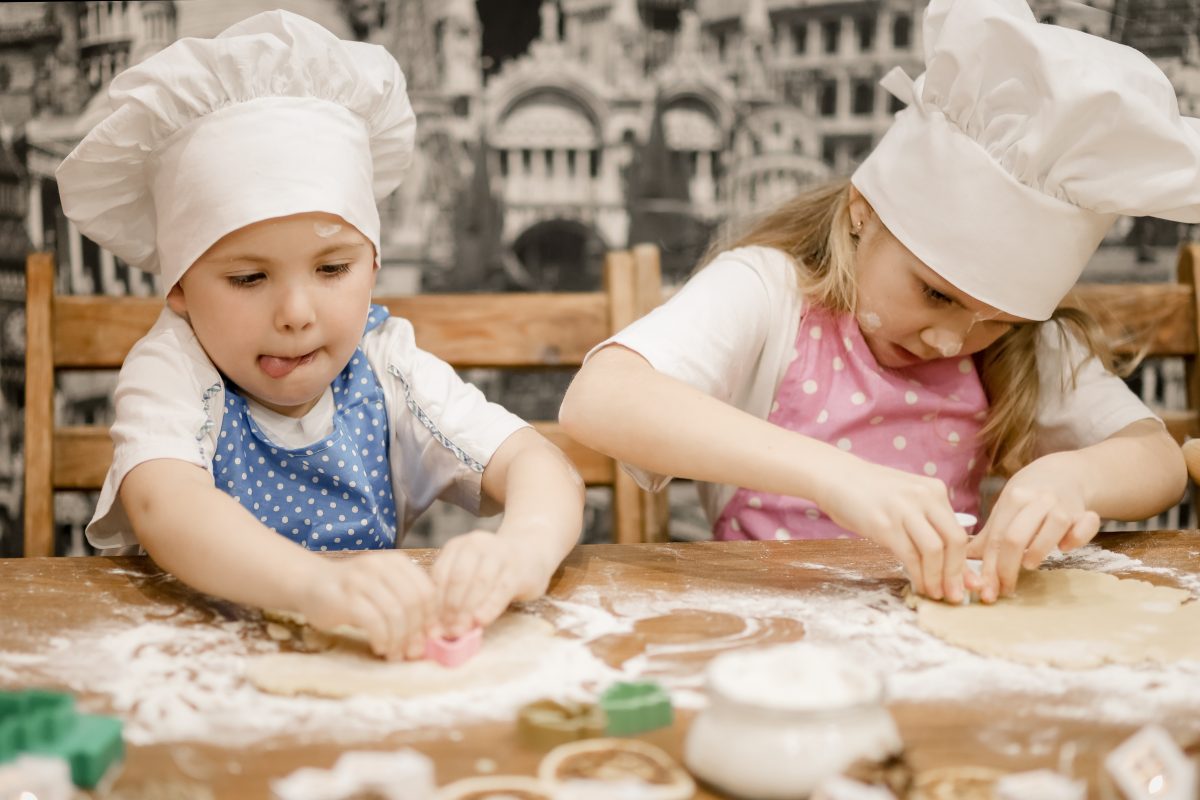Two children wearing chef's hats 
