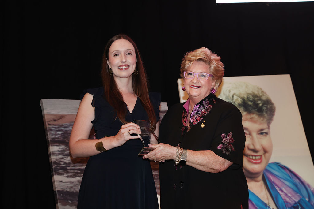woman presenting an award to another woman