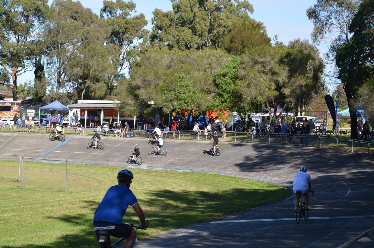 People ride bikes around a circuit