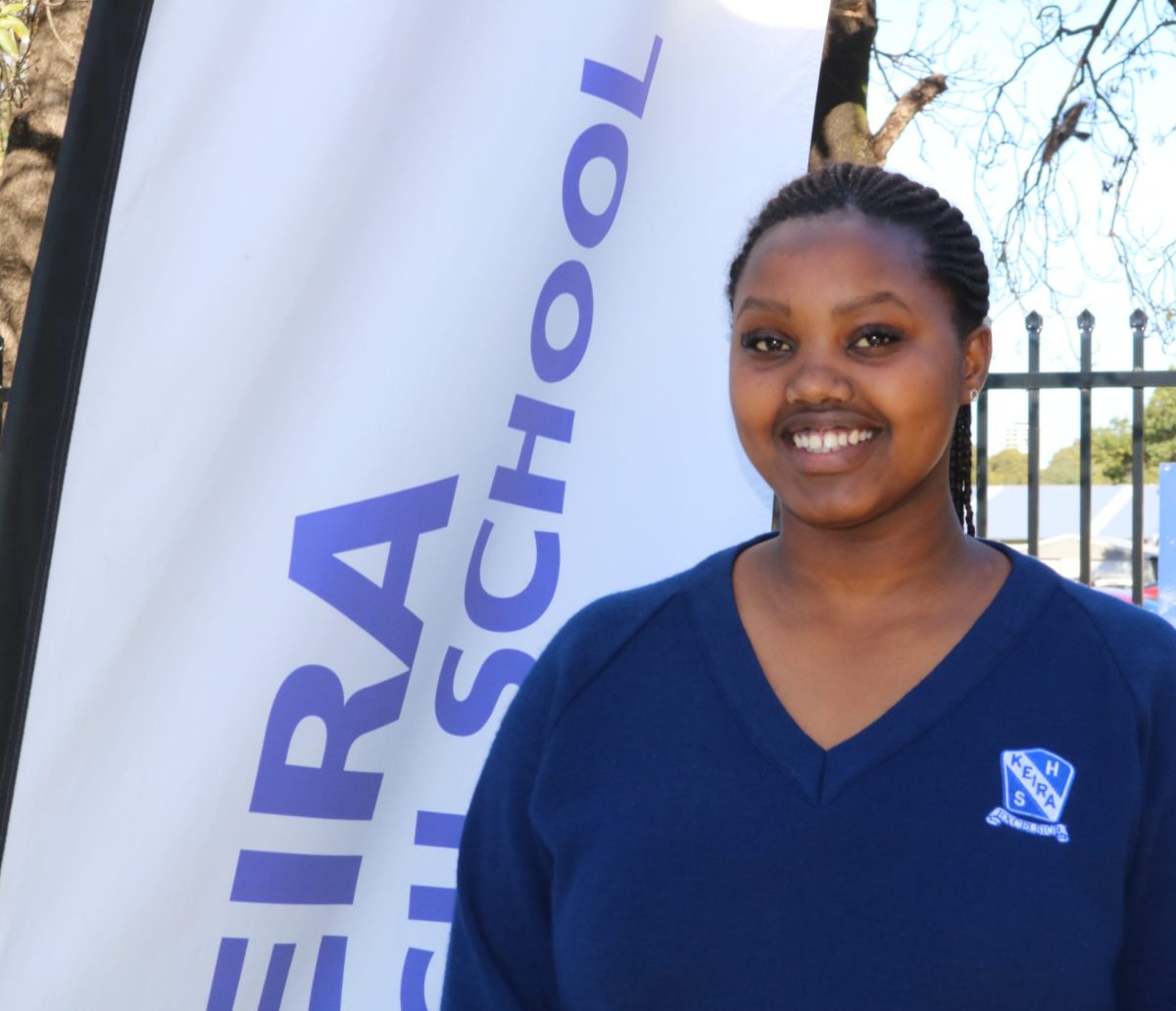 Schoolgirl in front of Keira High School flag.