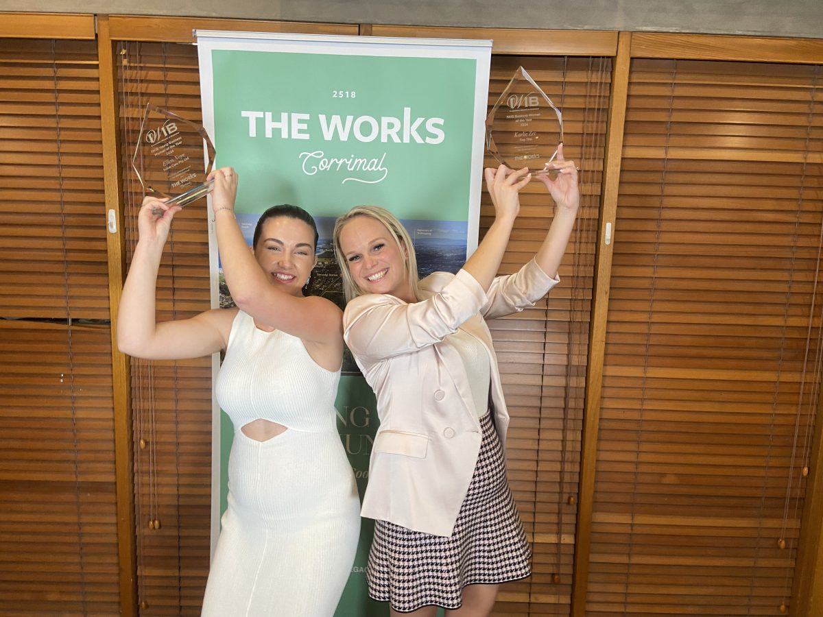 two women hold their awards up