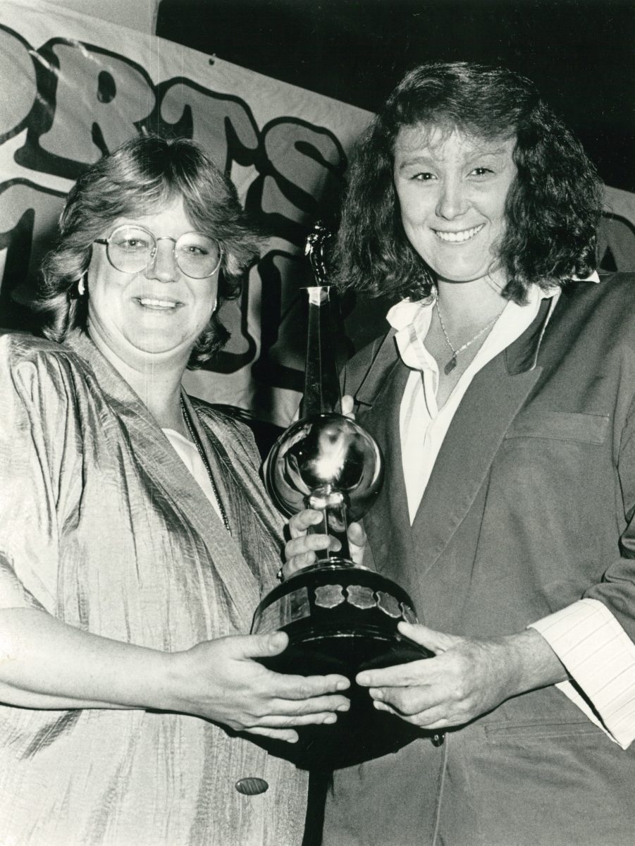Two women holding a trophy.