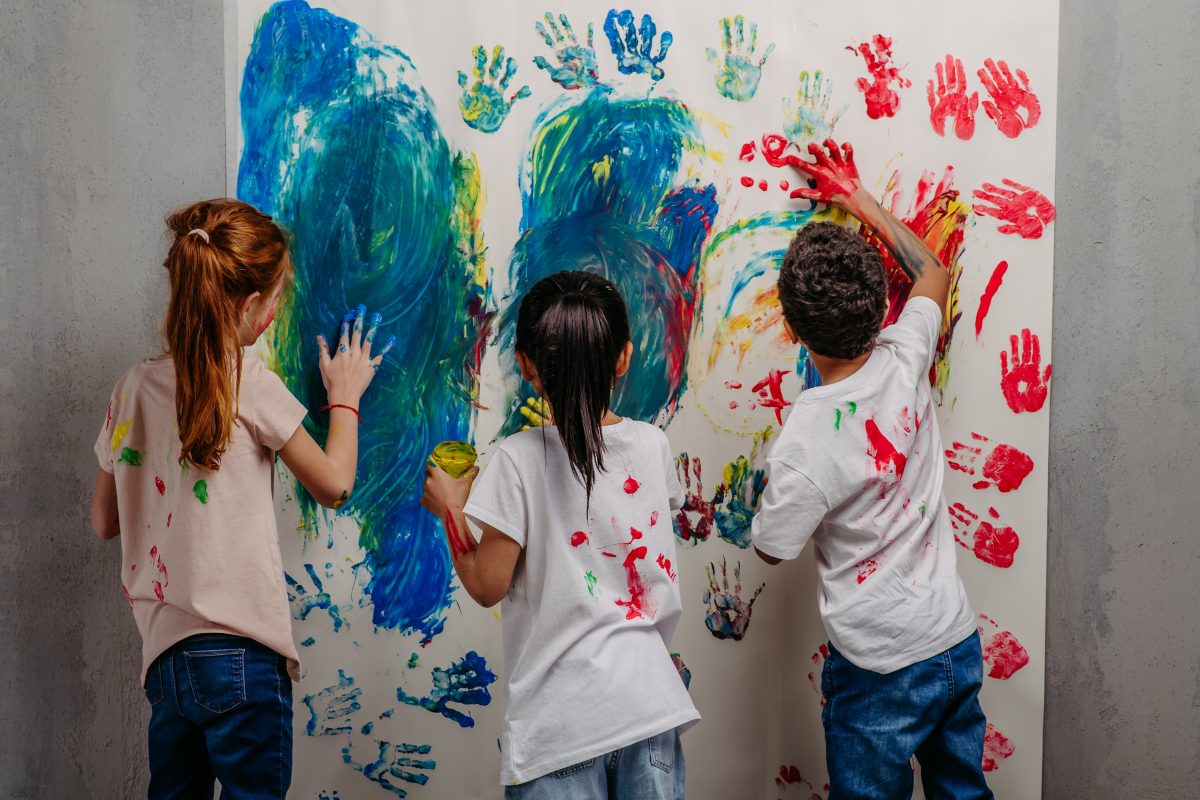 Rear view of happy kids with finger colours and painted T-shirts