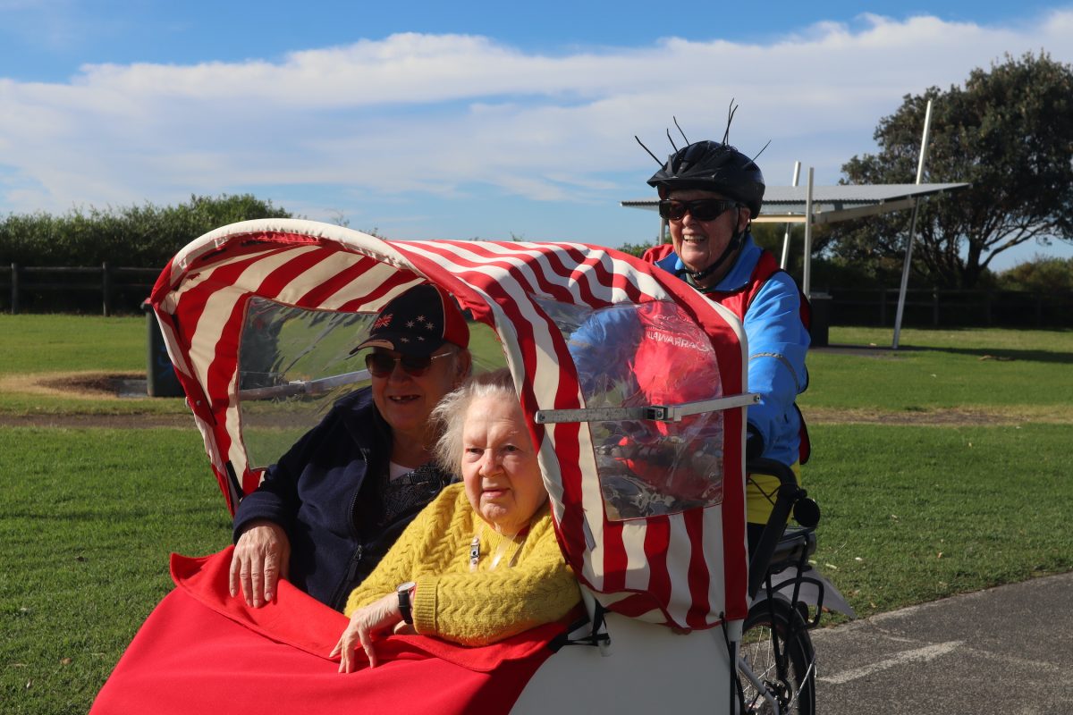 Three people riding along bike path.