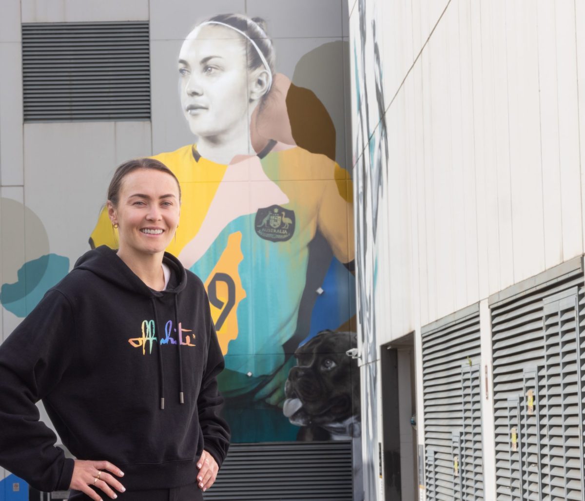 Caitlin Foord in front of the mural of her.