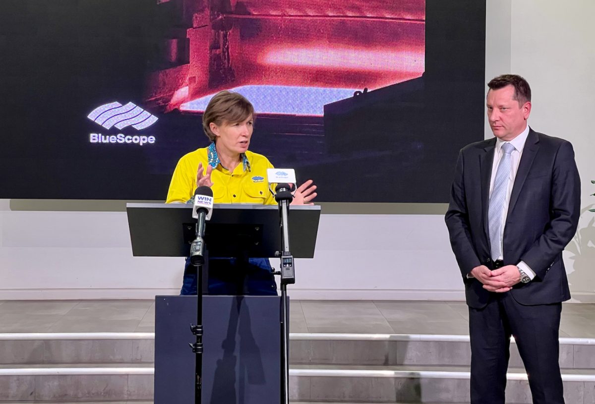 woman at lectern with man on stage