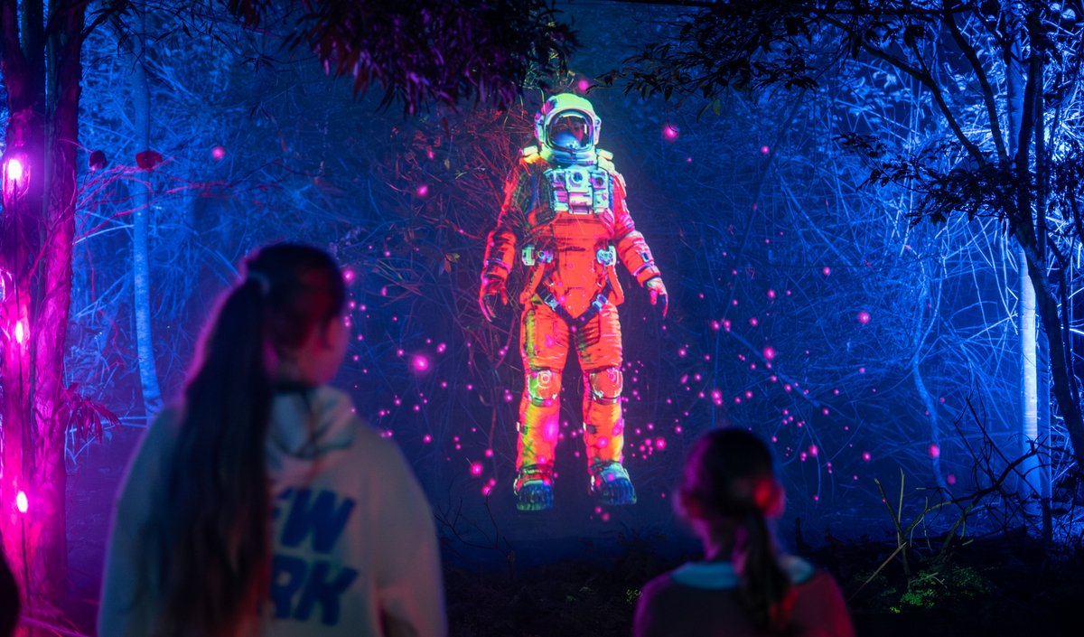 People explore Enchanted Forest The Lost Astronaut laser show at Blackbutt Forest