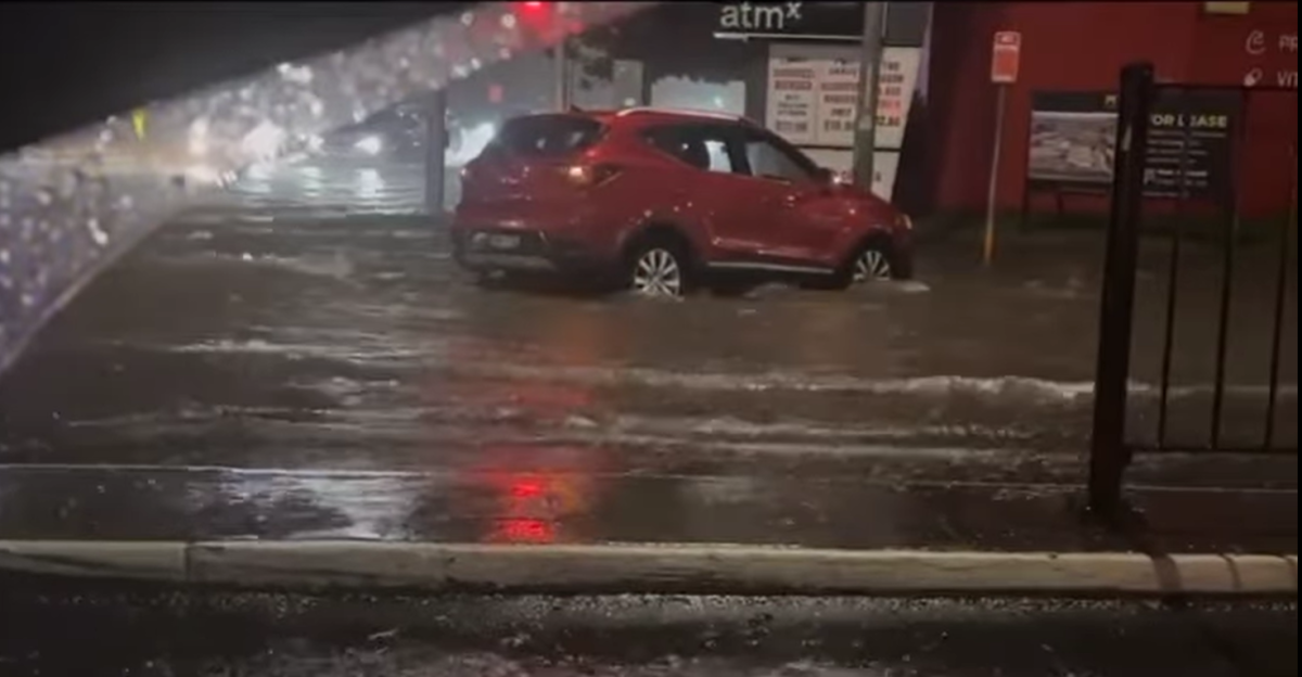 A red car in a flooded street.