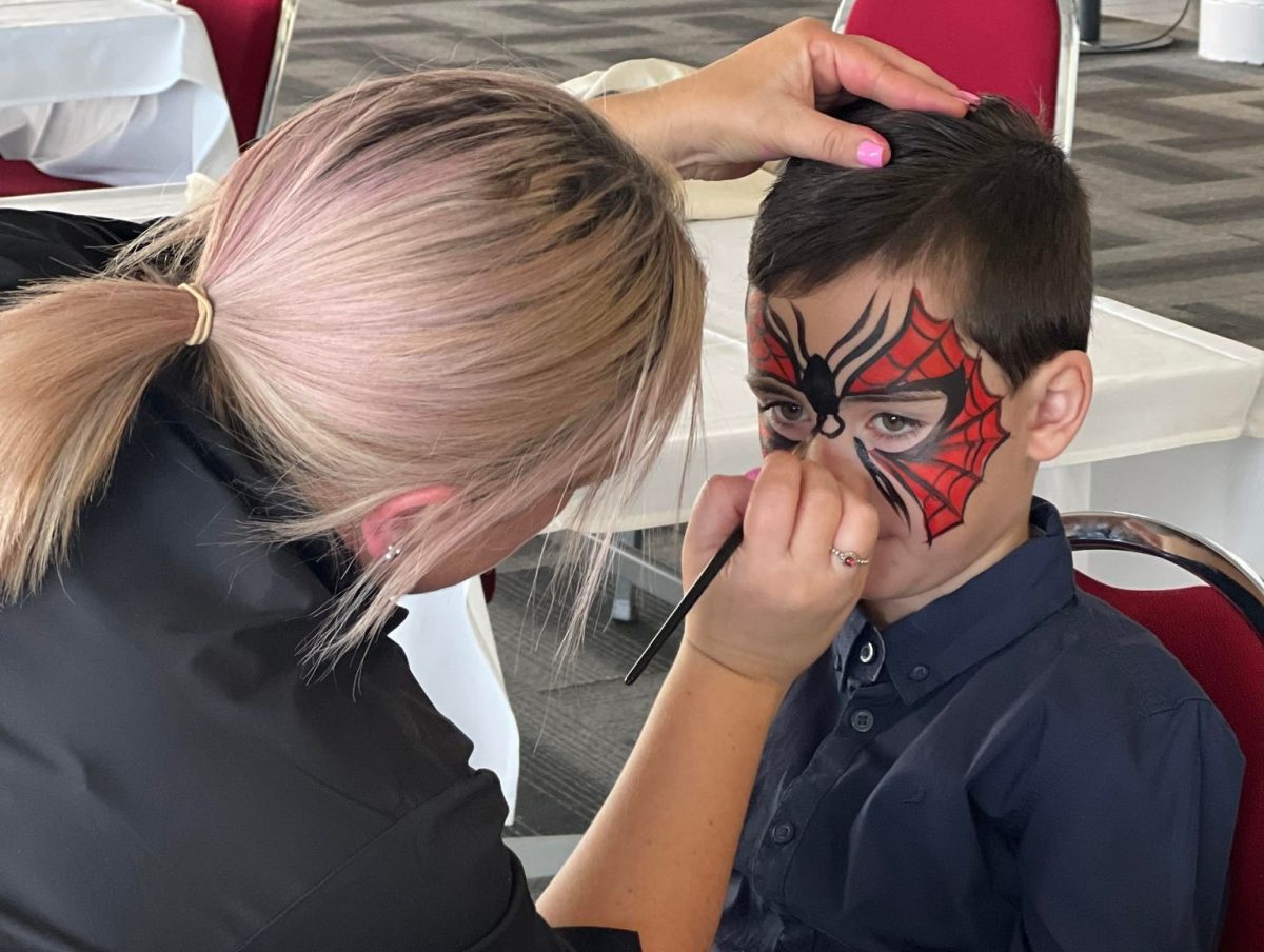 Boys gets face painted as spiderman