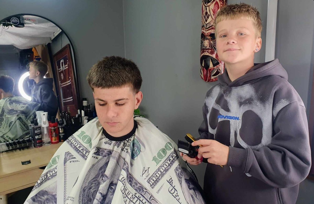 young barber cutting another boy's hair