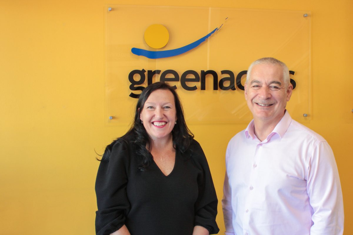 a woman and a man in front of a business sign