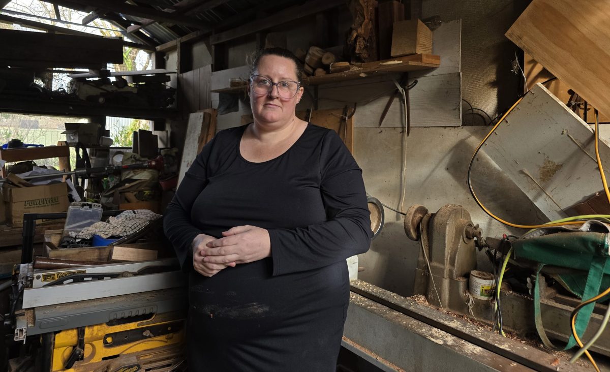 Woman standing in woodworking studio.