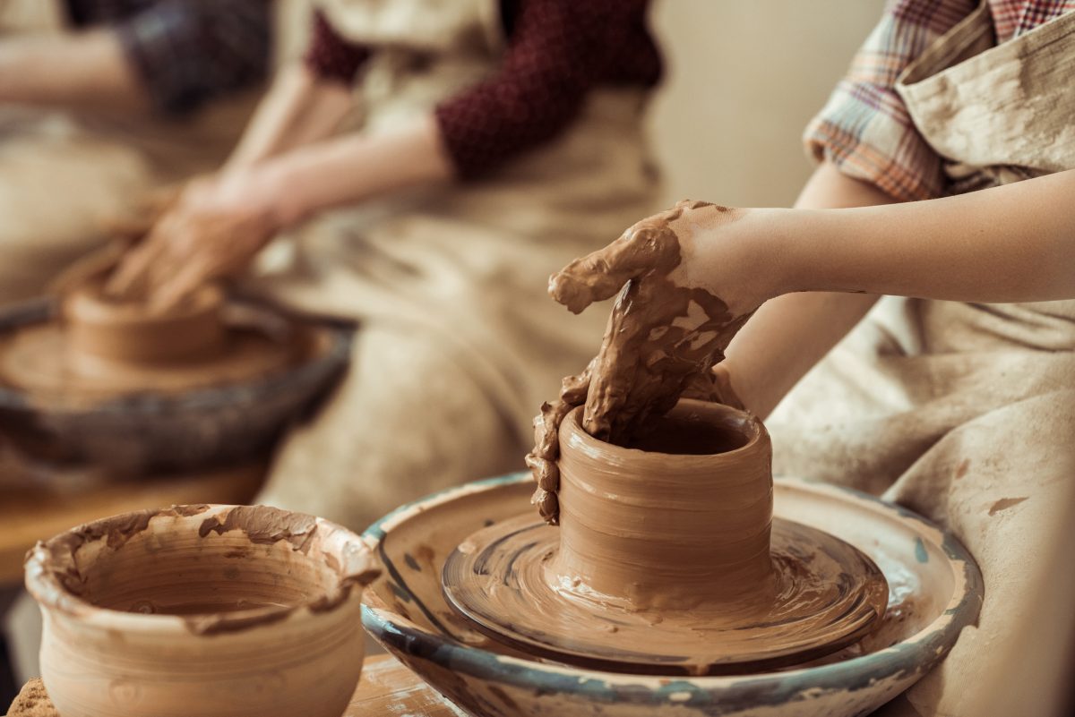 Close-up of child hands working on pottery wheel at workshop