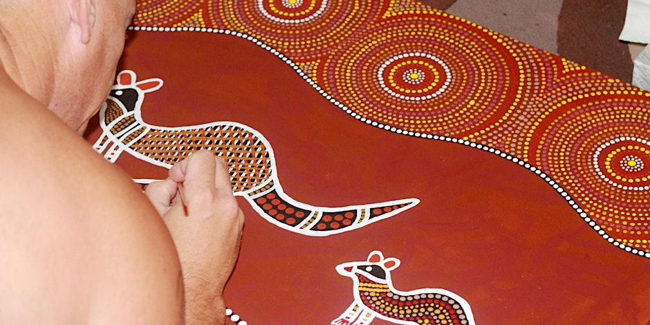 Artist in action creating Aboriginal art