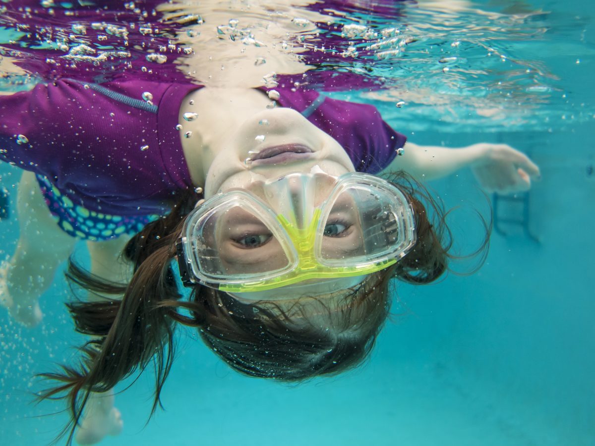 little girl swimming underwater having fun