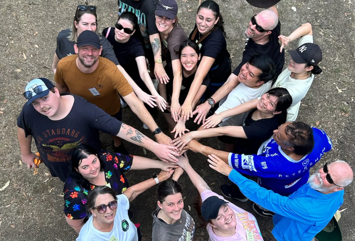 people standing in a circle and joining hands