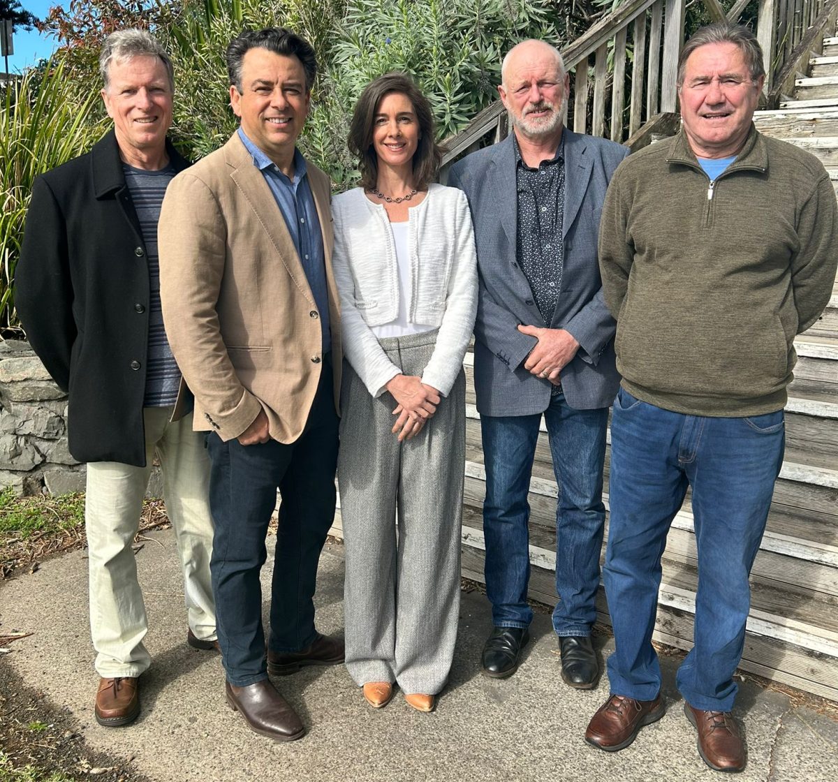 Five people standing in front of stairs