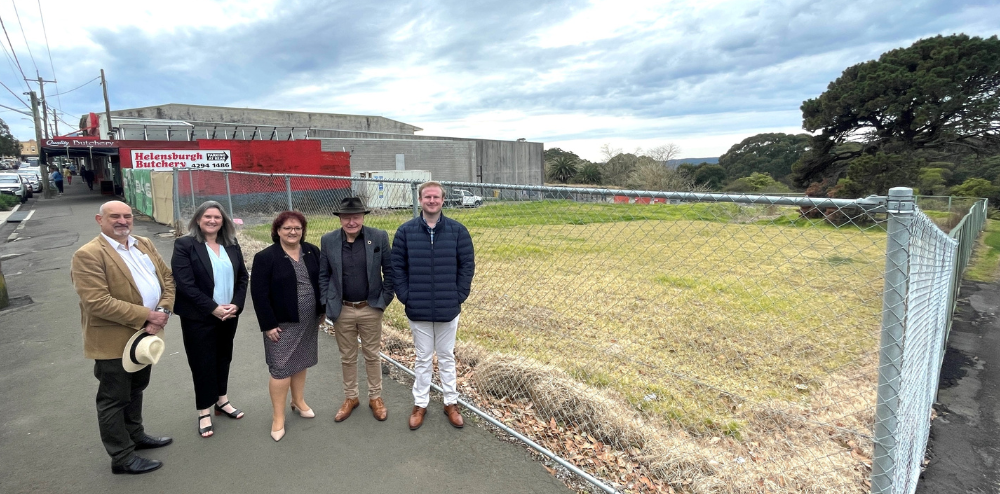 five councillors standing next to a vacant development site