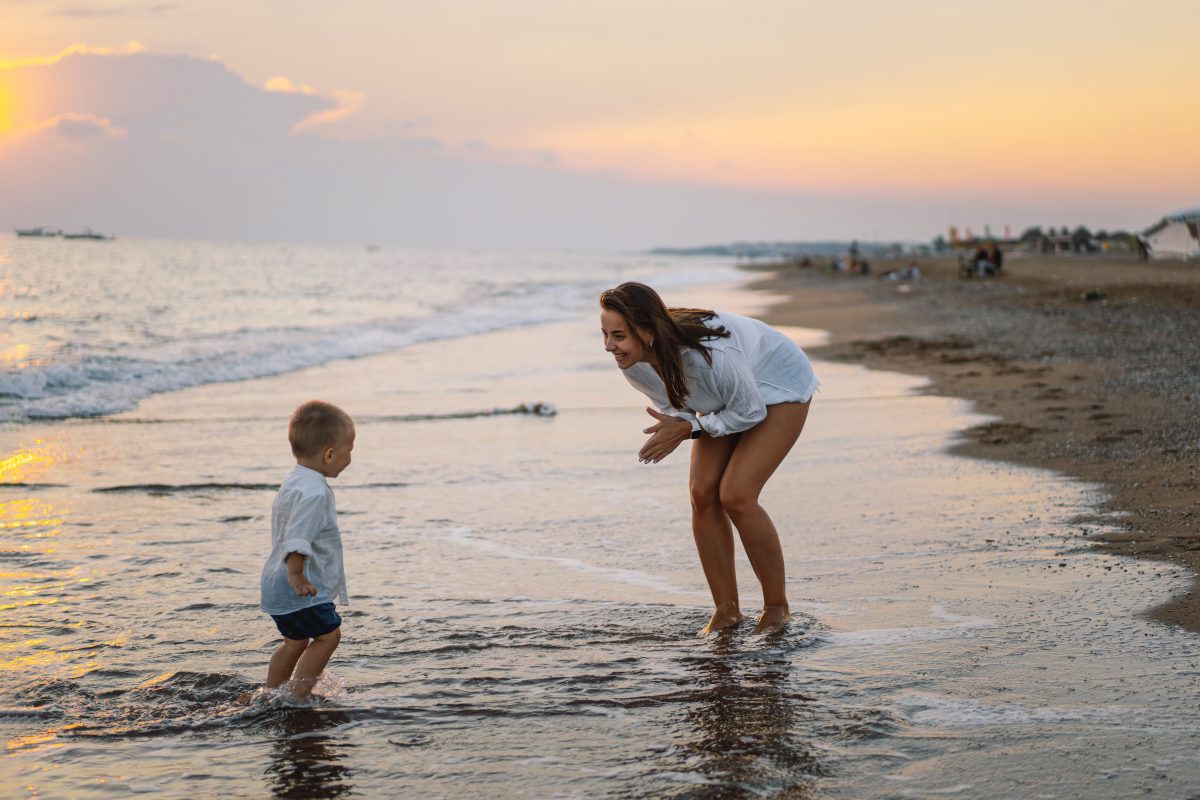 Happy mother with son playing on the beach