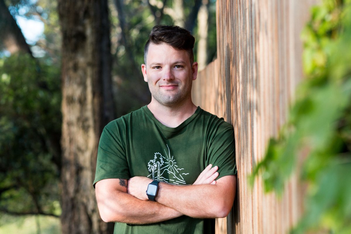 man leaning against a fence