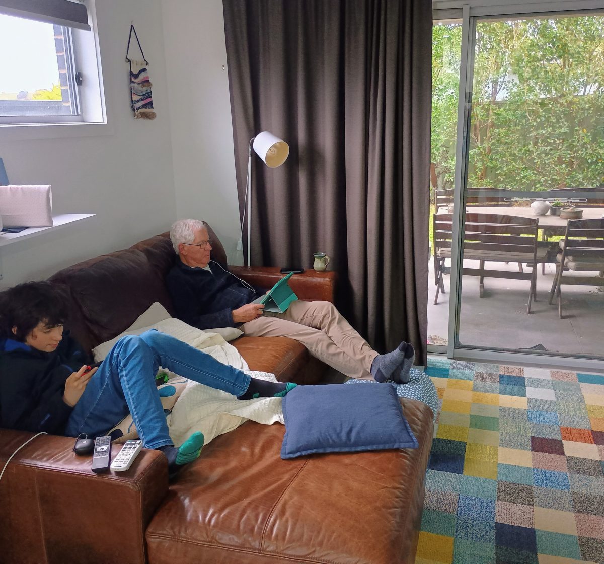 Older man and teenager on a sofa.