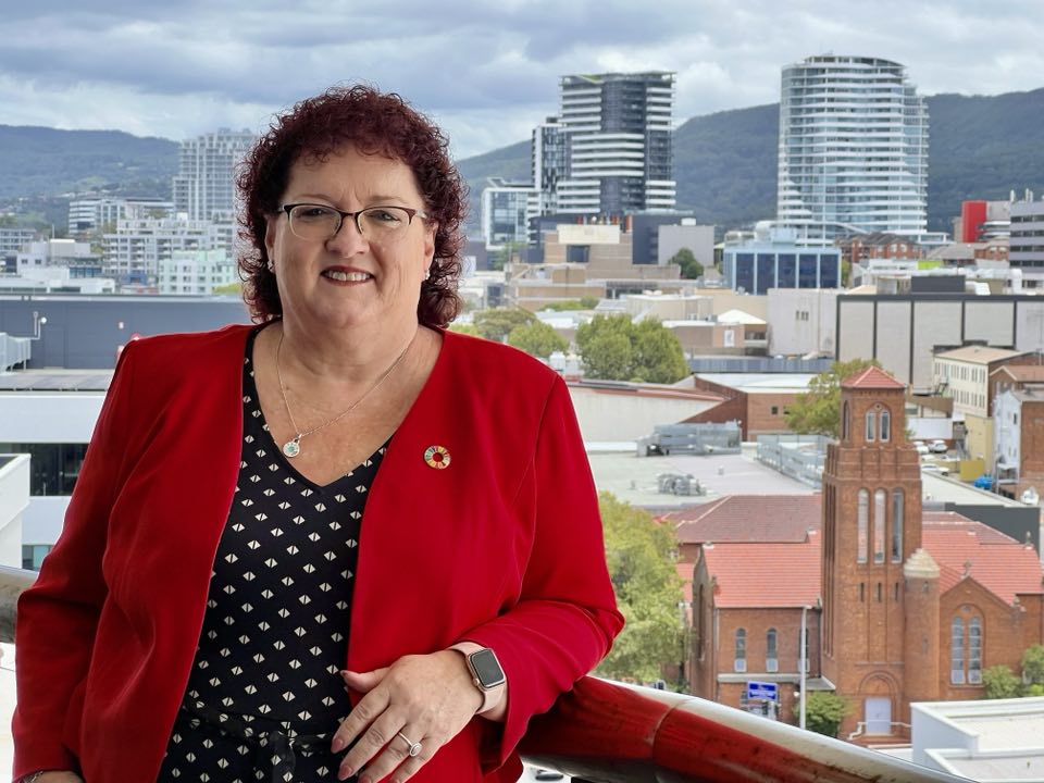 smiling woman standing on a balcony