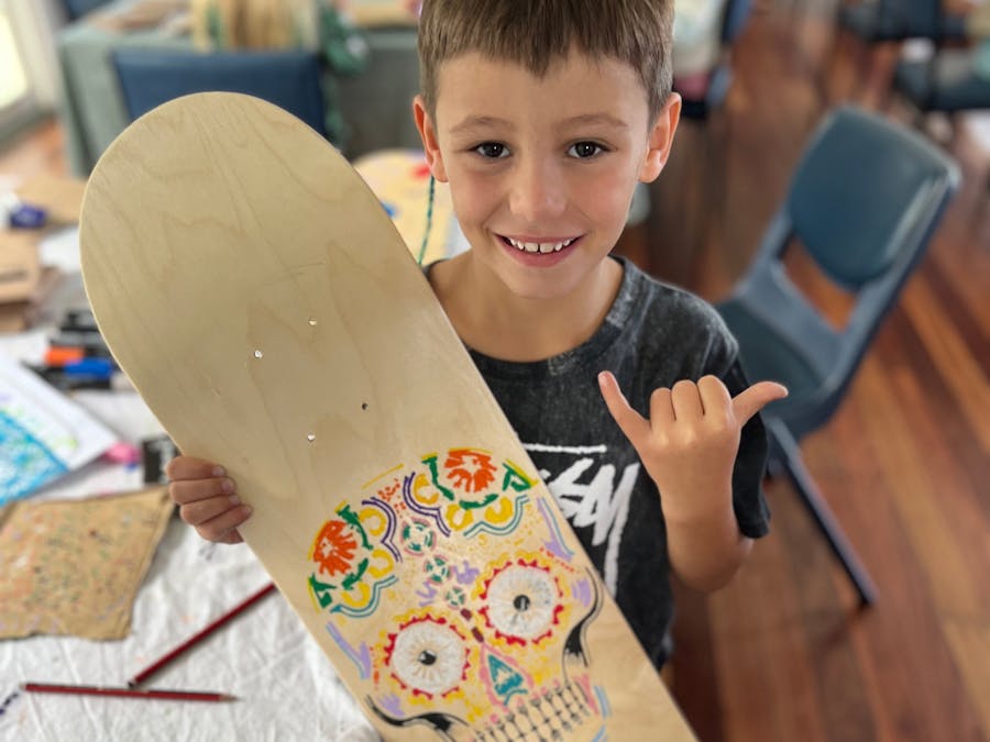 Child holding hand painted skateboard