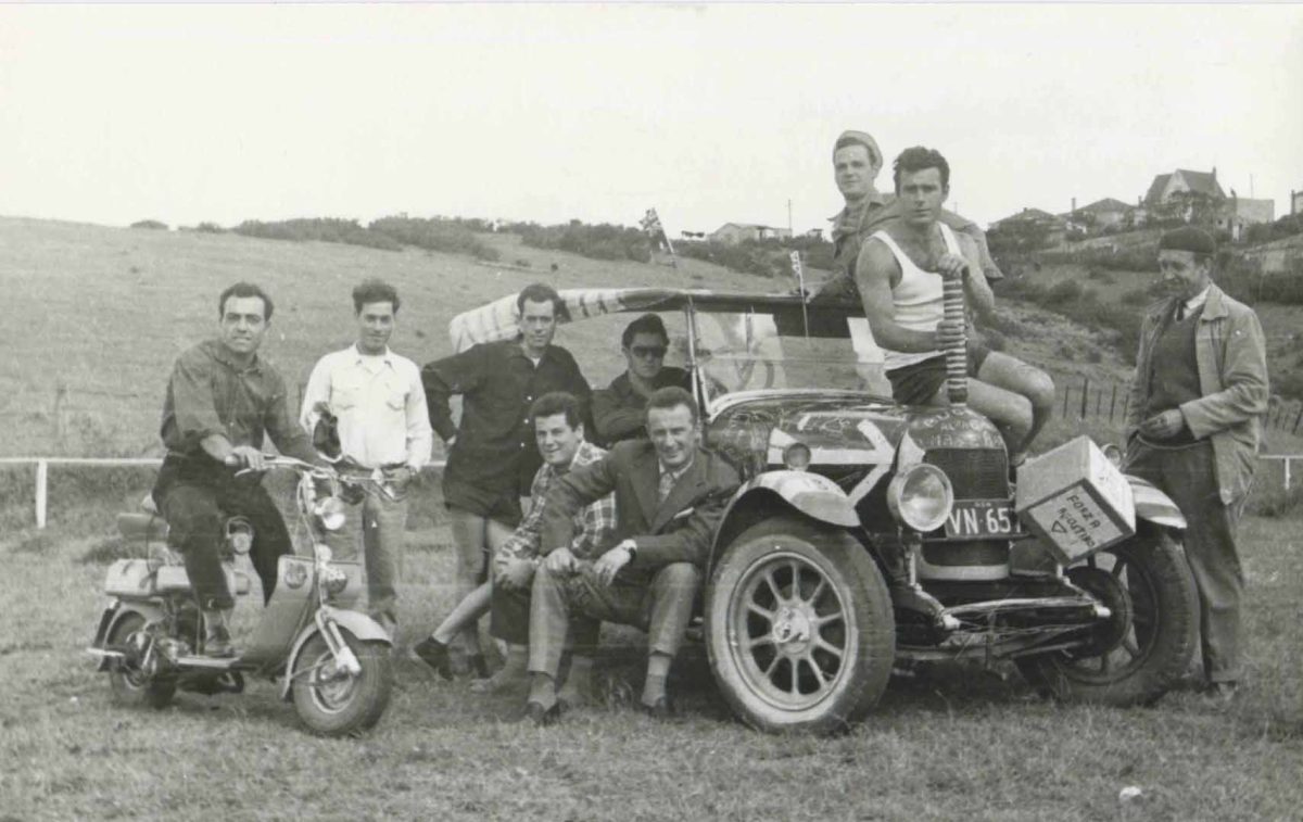 Men sitting around a car