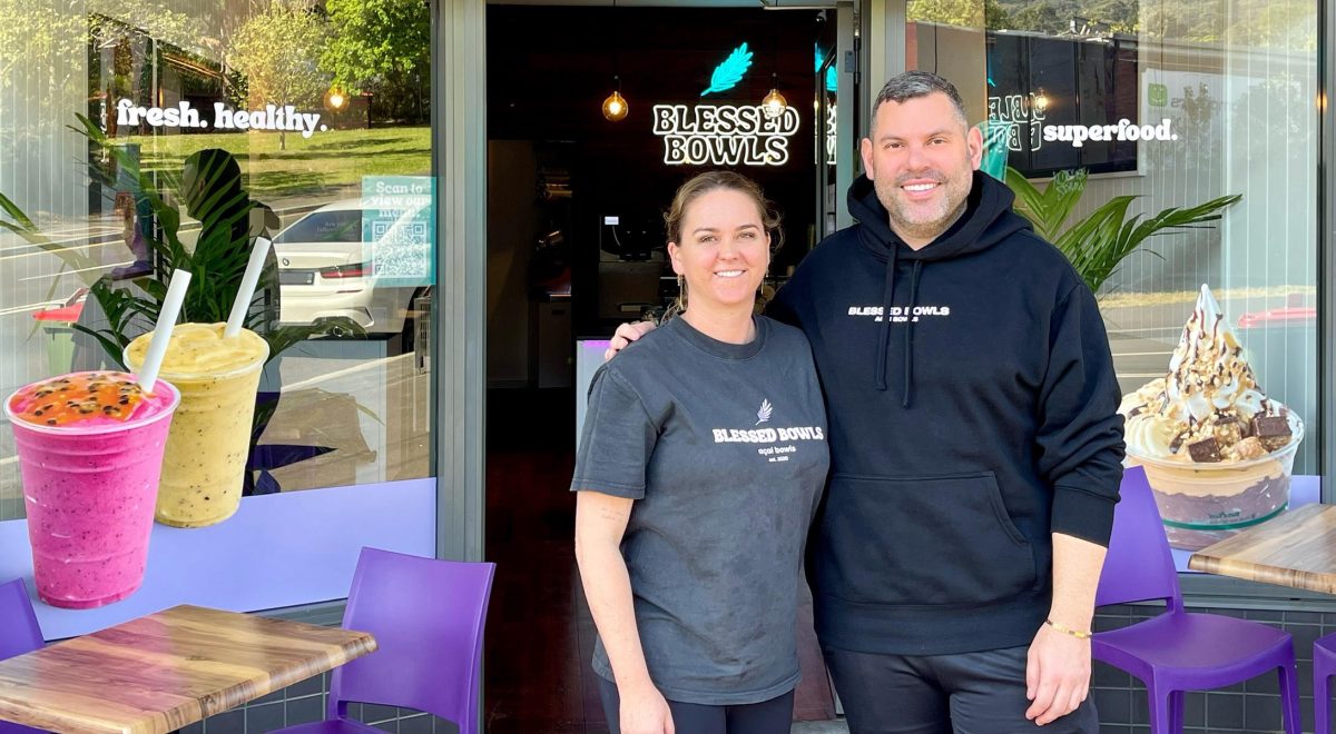 Blessed Bowls Thirroul owners Saskia Martin and Adrian Erdedi stand outside their shop and smile