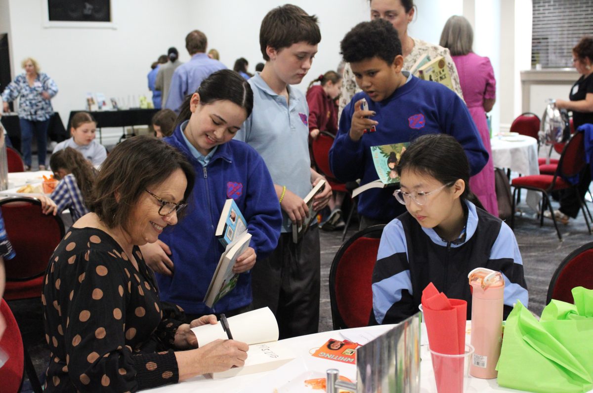 Sue Whiting signing books for students at literary lunch.