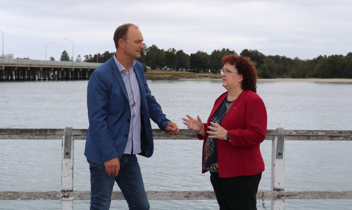 Two people standing near a lake