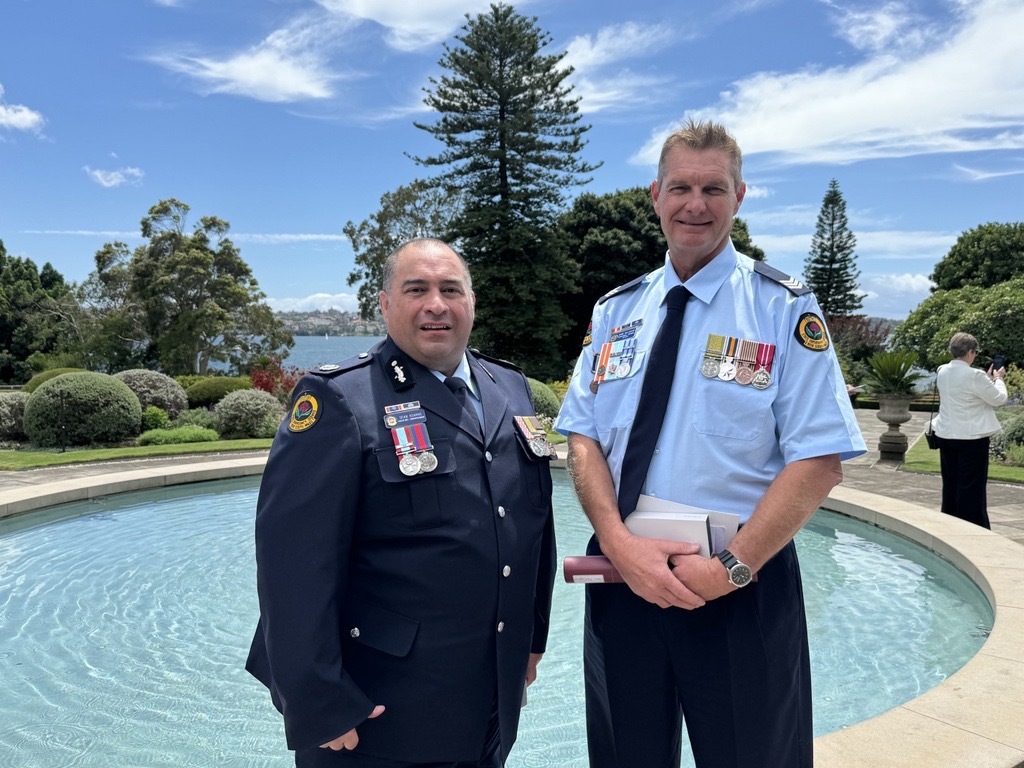 two SES men standing by a fountain