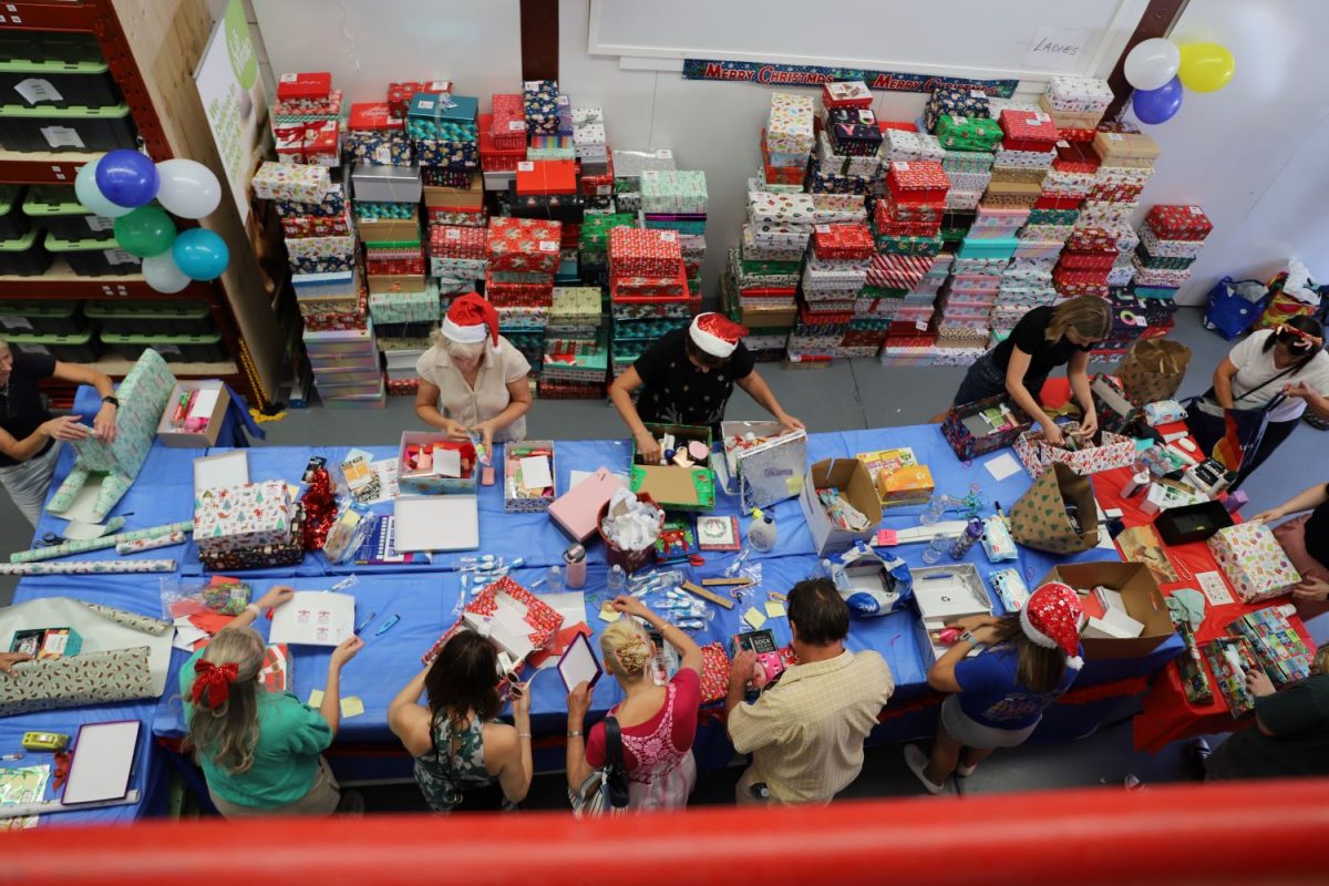 Group of people wrapping Christmas presents