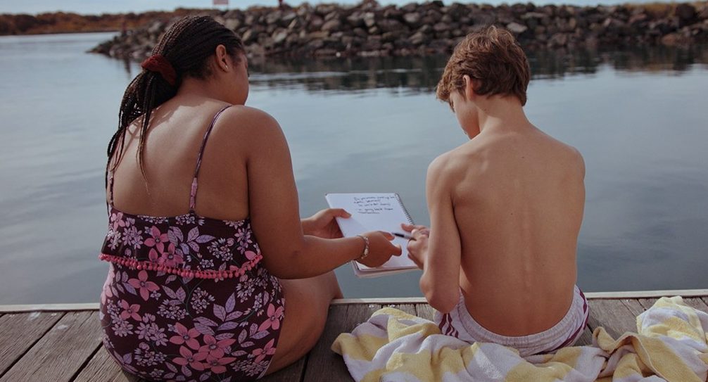 Girl and boy on a pier at a lake