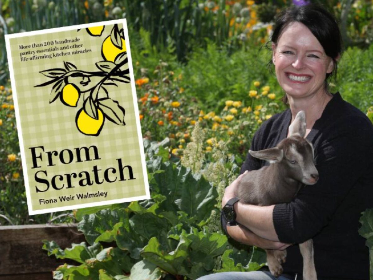 author Fiona Weir holds a goat in a garden