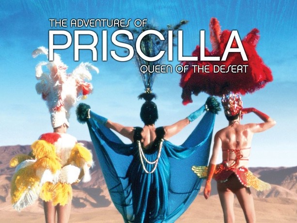 Still from Priscilla Queen of the Desert the film showing three drag queens from behind