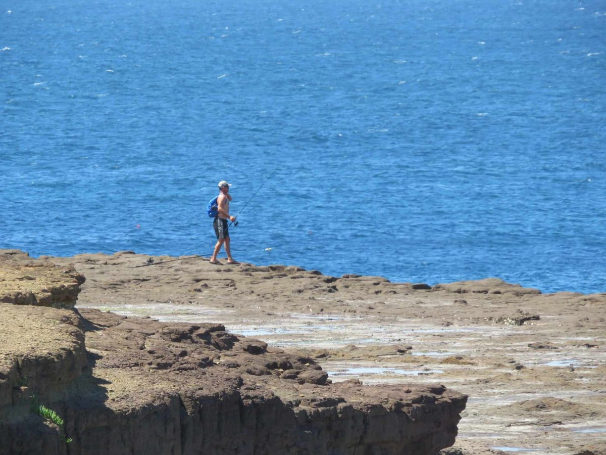 Despite a $100 fine for rock fishers found not wearing life jackets, this fisherman at Hill 60 is unconcerned.