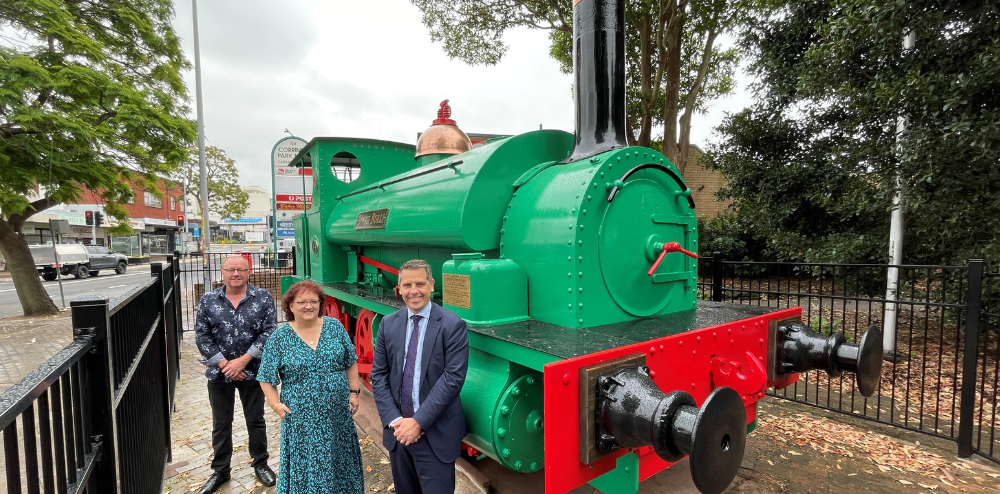 Three people and green train loco