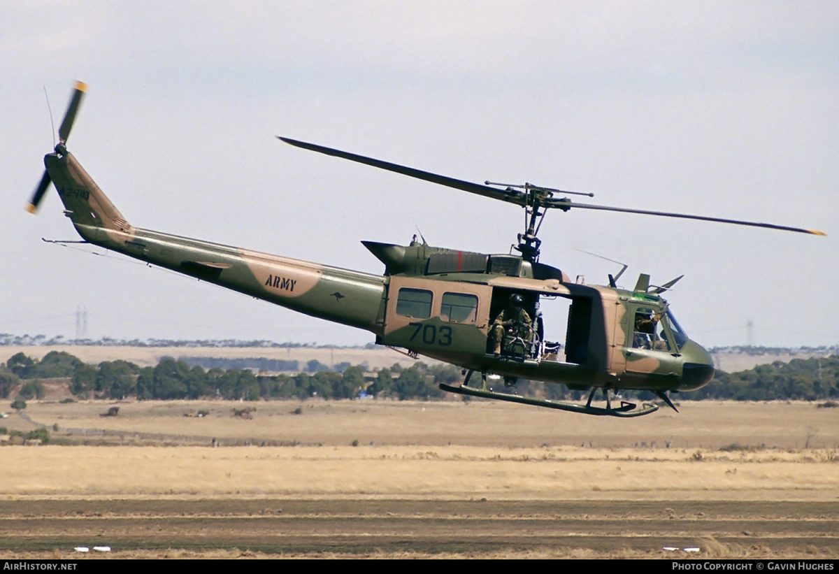 A camouflage coloured helicopter comes in to land