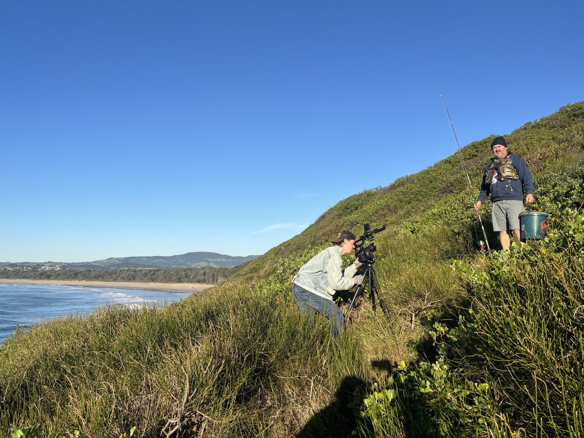 People filming by the ocean