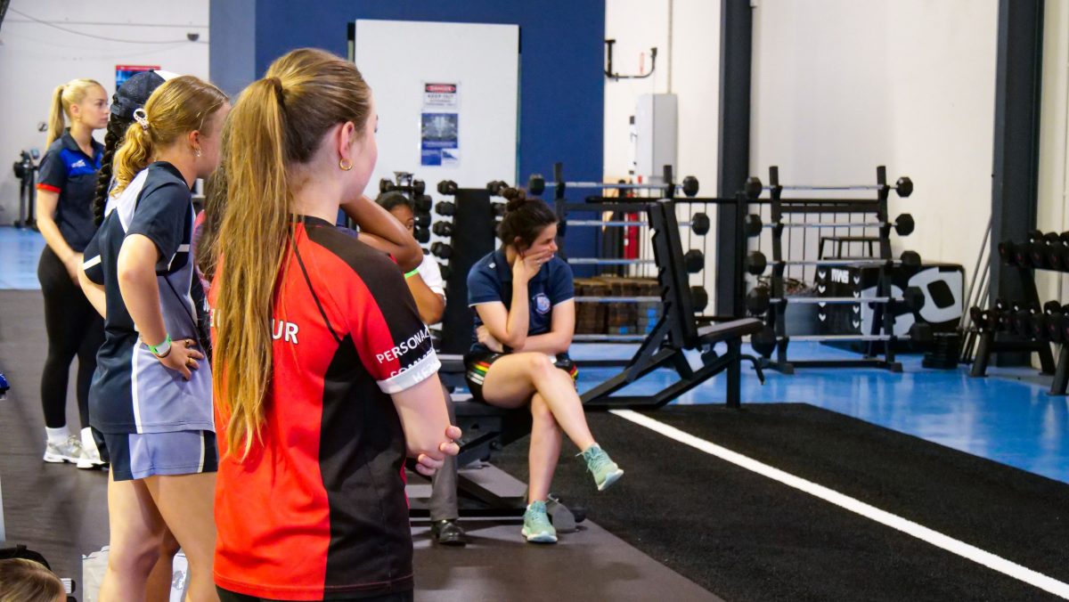 Female athletes in gym during performance program. 