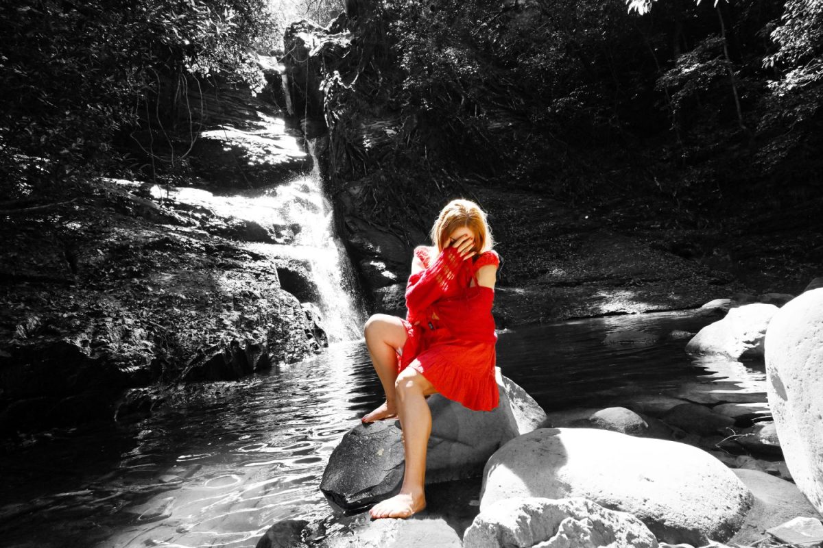 Woman in red sitting on a rock