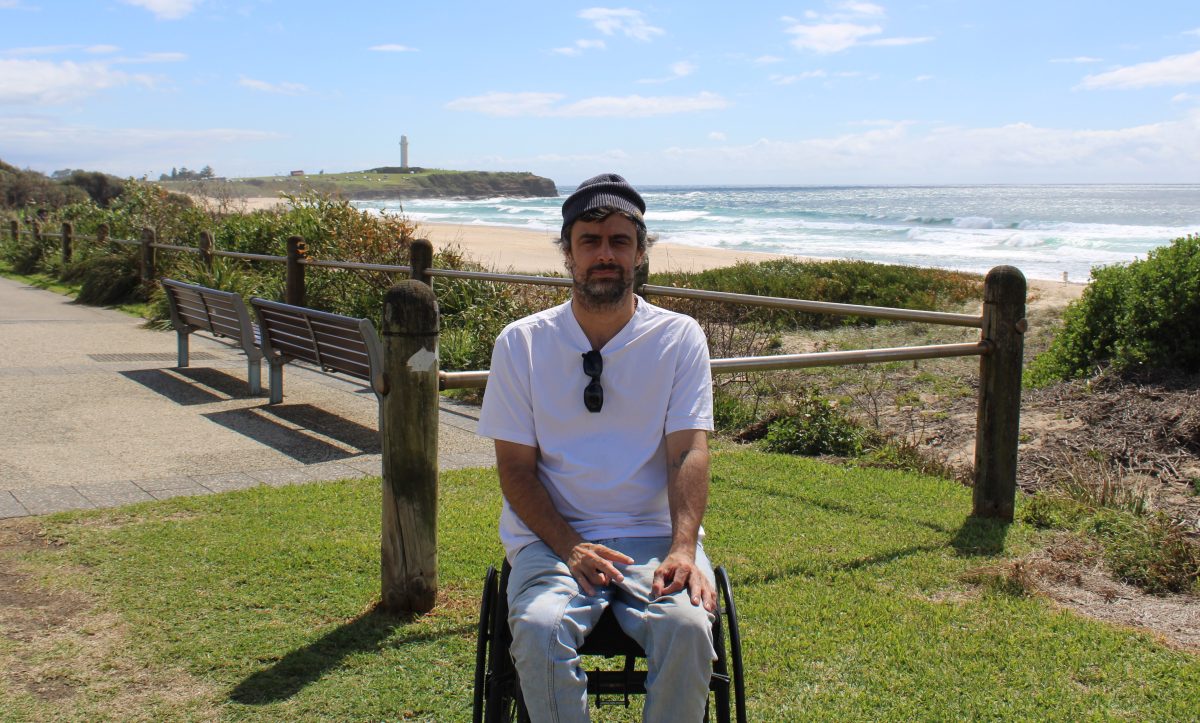 man in a wheelchair on a beach foreshore