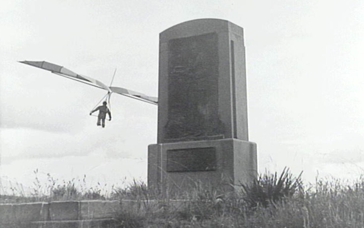 Hang glider behind a statue