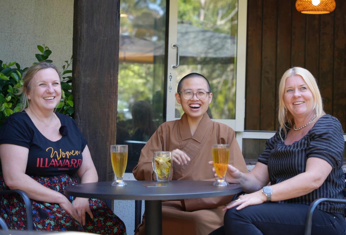 three women sitting at a table and having a drink