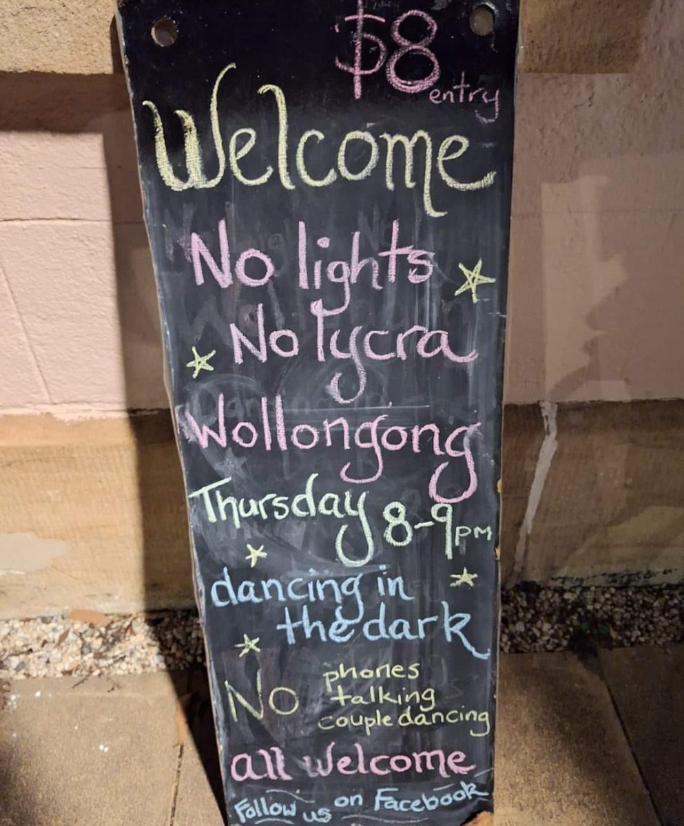 No Lights No Lycra sign reads: $8 Entry, No Lights No Lycra Wollongong, Thursday 8 - 9pm, Dancing in the Dark, No Phones, No Talking, No Couple Dancing.