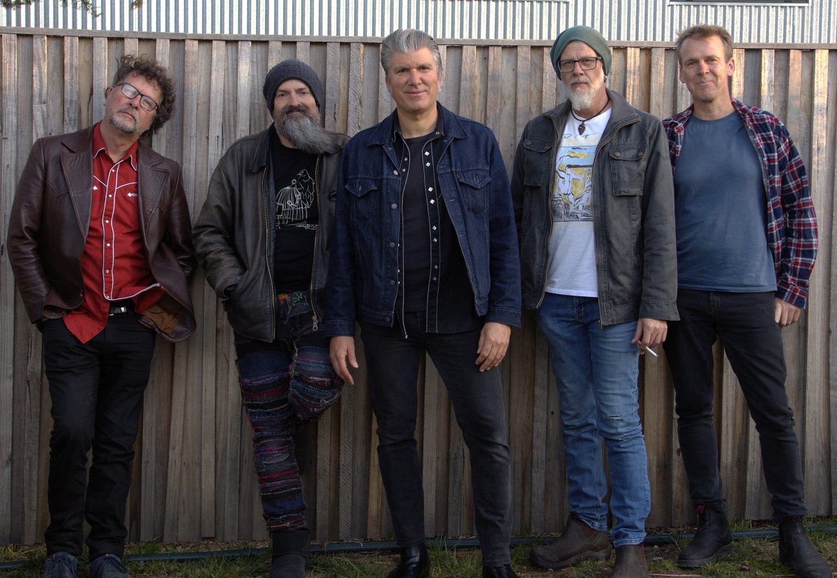 Band members of Mikelangelo and the Long Lost Friends stand in front of a metal wall