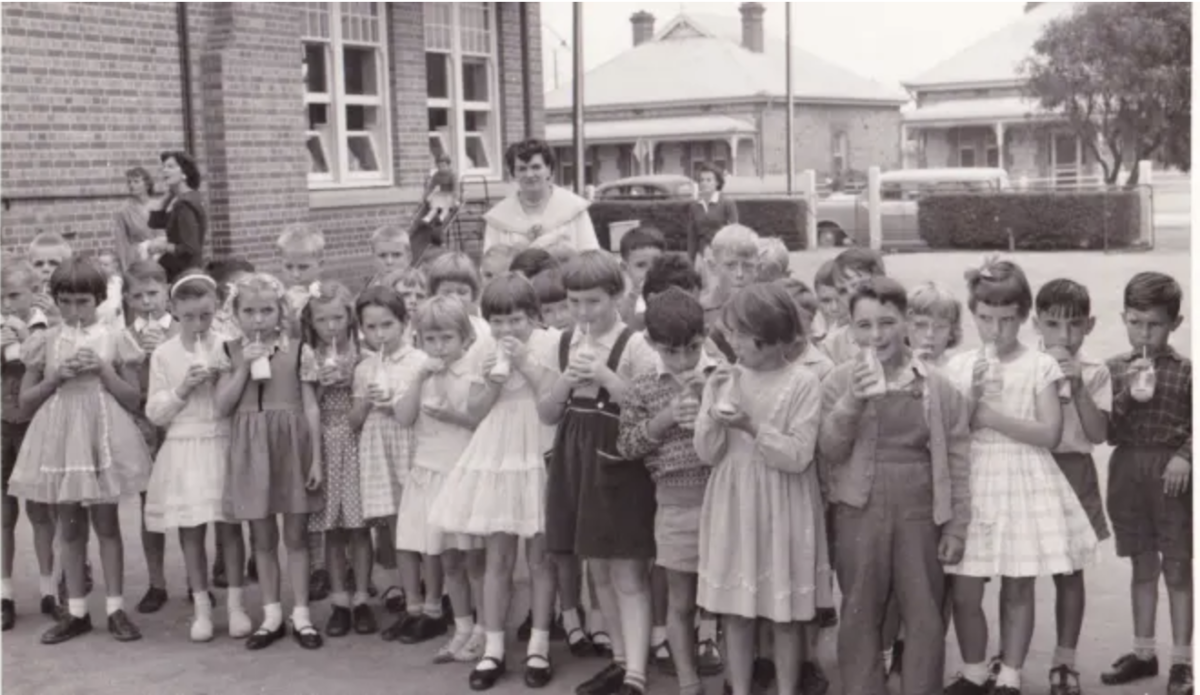 Group of school children drinking milk