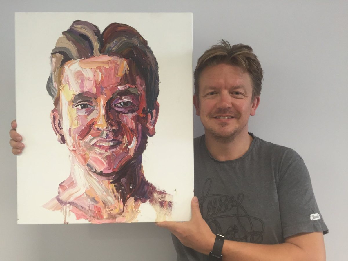 Nick Bolton holds up a portrait of himself by Myu Sukamaran