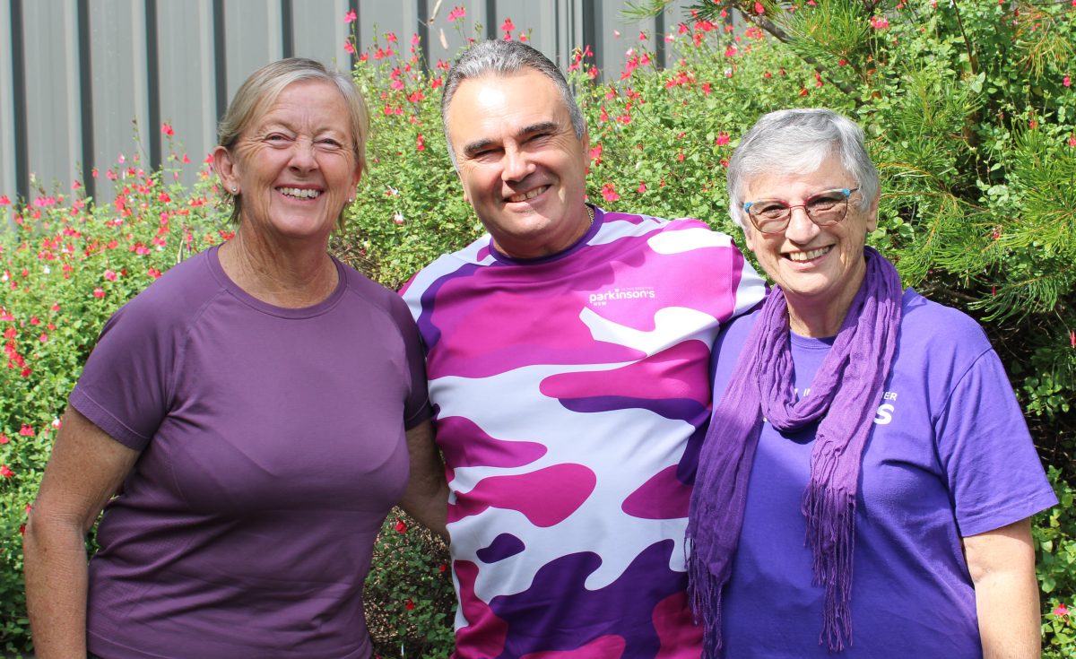 two smiling women and a smiling man